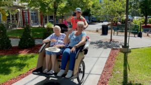 Creekside residents head out with their pilot on a trishaw to visit the neighborhood.